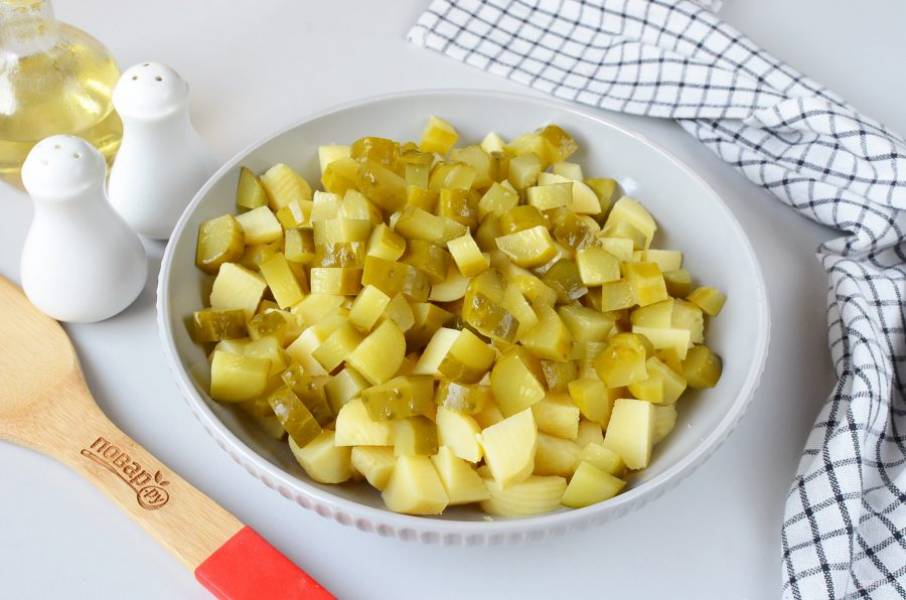 Порежьте крупно соленые огурчики, добавьте к картофелю.