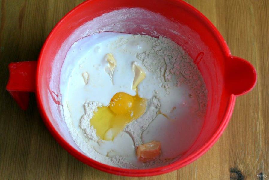 В просеянную с разрыхлителем муку добавьте соль, кефир комнатной температуры и размягченное сливочное масло.  Быстро замесите мягкое липкое тесто. Не забивайте тесто мукой.