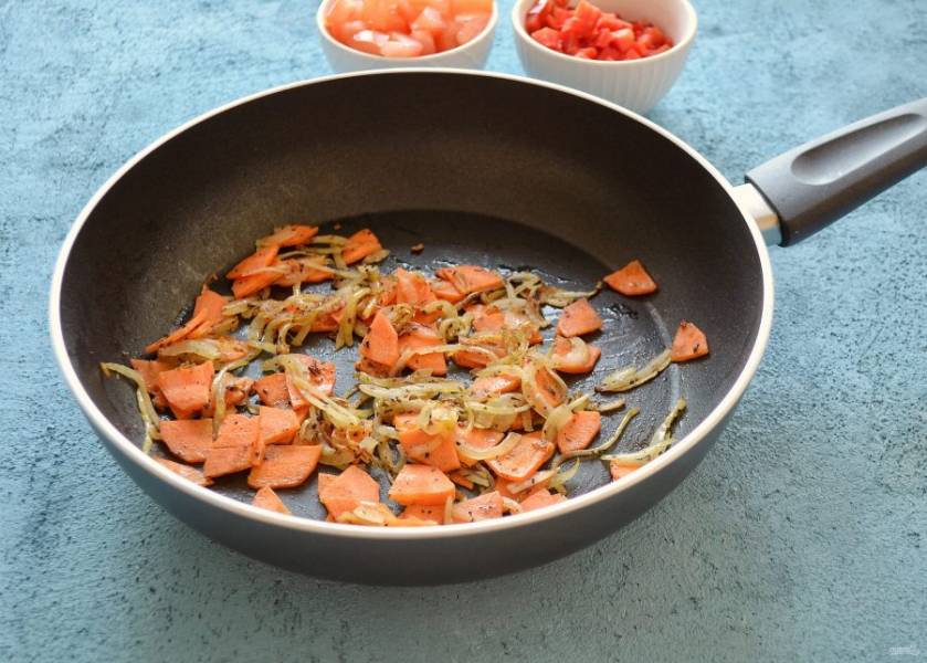Разогрейте сковороду на среднем огне, обжарьте пару секунду специи и чеснок, чтобы они раскрыли аромат. Добавьте лук и морковь, обжарьте их до полуготовности. 