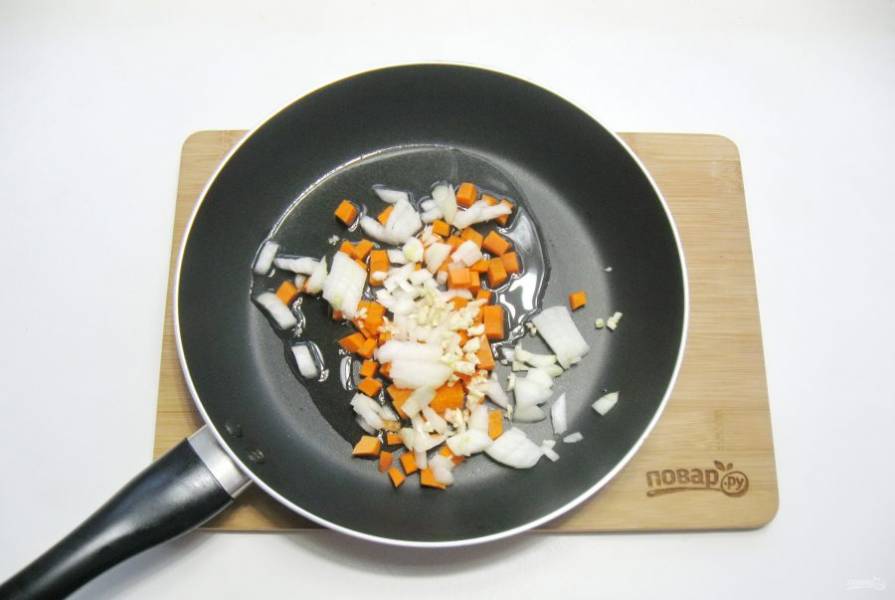 Чеснок очистите, измельчите и добавьте в сковороду к моркови и луку.