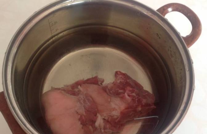 Свинину промойте, поместите в кастрюлю и залейте холодной водой. Доведите до кипения, а потом варите еще 5 минут. Затем слейте воду, мясо немного остудите и порежьте кусочками. Вновь заливаем мясо водой, варим еще 15 минут.