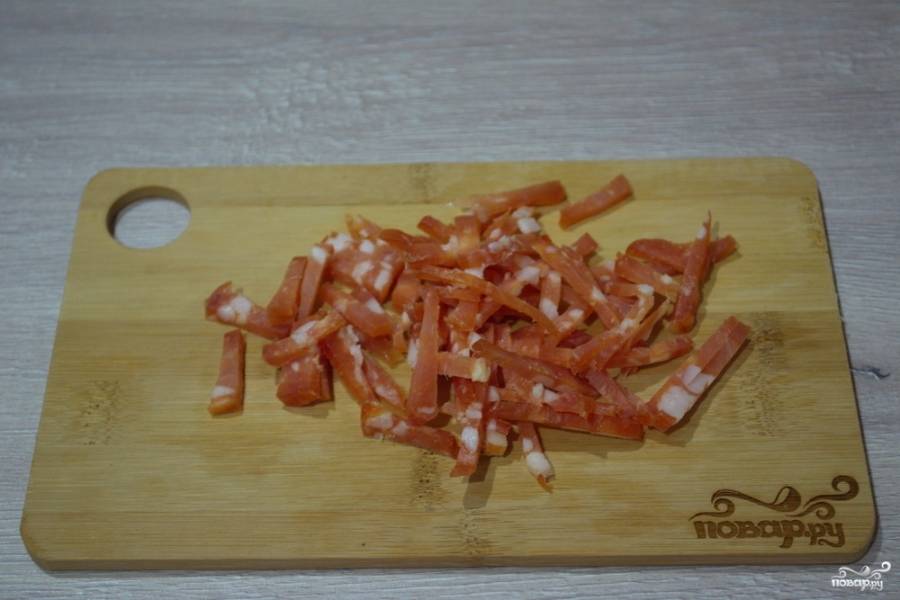Как приготовить салат с салями и кукурузой? Колбасу нарезаем небольшими полосками. Лучше использовать острый нож.
