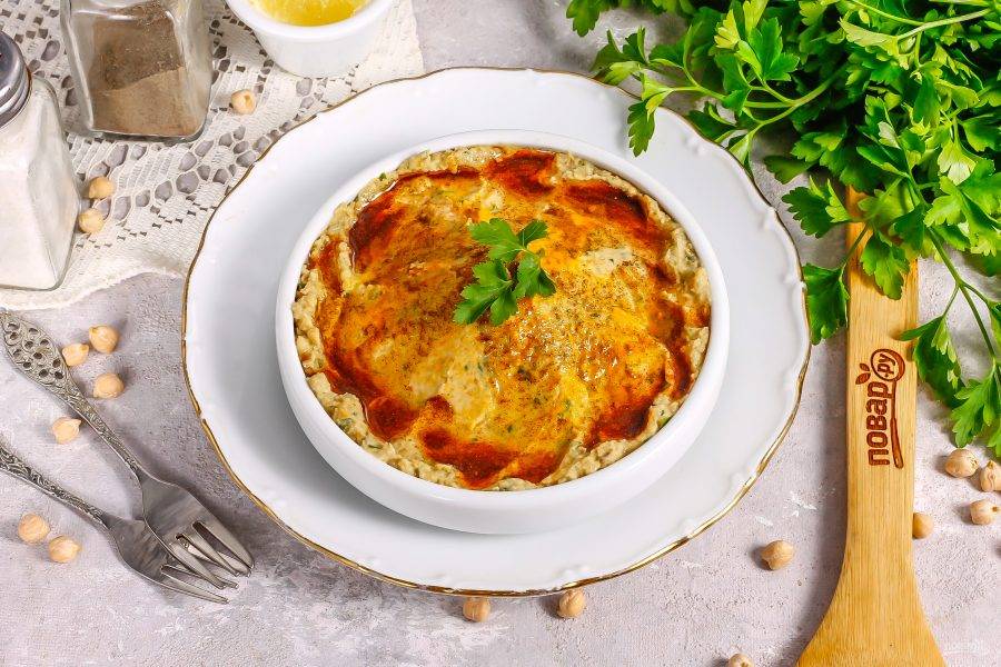 Выложите хумус на тарелку и украсьте по вкусу. Можно смешать молотую паприку и куркуму с оливковым маслом и полить блюдо сверху.