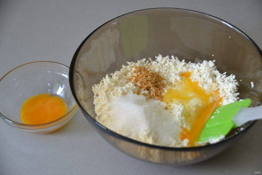 Добавьте 1,5 ст. ложки сахара, ванильный сахар, лимонную цедру, вбейте 1 яйцо, оставив примерно половину желтка для смазывания перед выпечкой.
