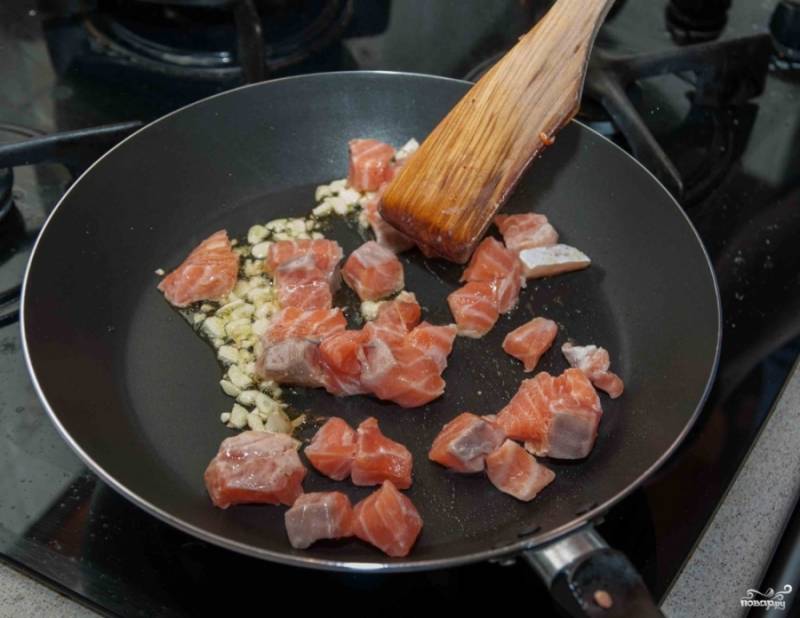 На сковороде обжарьте в небольшом количестве масла оливкового чеснок, пускай даст аромат. Потом к нему выложите форель, обжаривайте минуты 4.