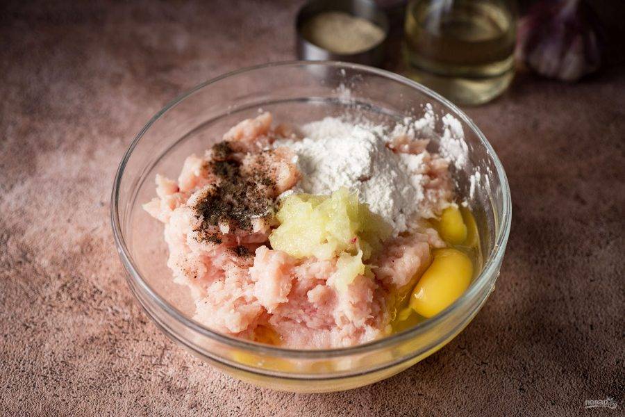 Лук чистим, трем на мелкую терку, добавляем к рубленому мясу. Туда же вбиваем яйца,
добавляем соль, перец, крахмал, чеснок выдавливаем через чеснокодавилку.
Перемешиваем.