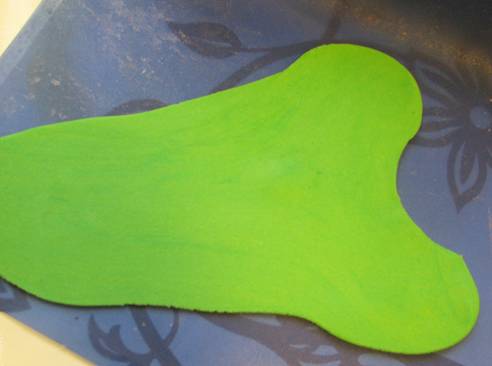 2. Первый цвет, с которым нужно работать, - это зеленый. Из мастики раскатать кусочек на треть больше, чем ноги куклы. 