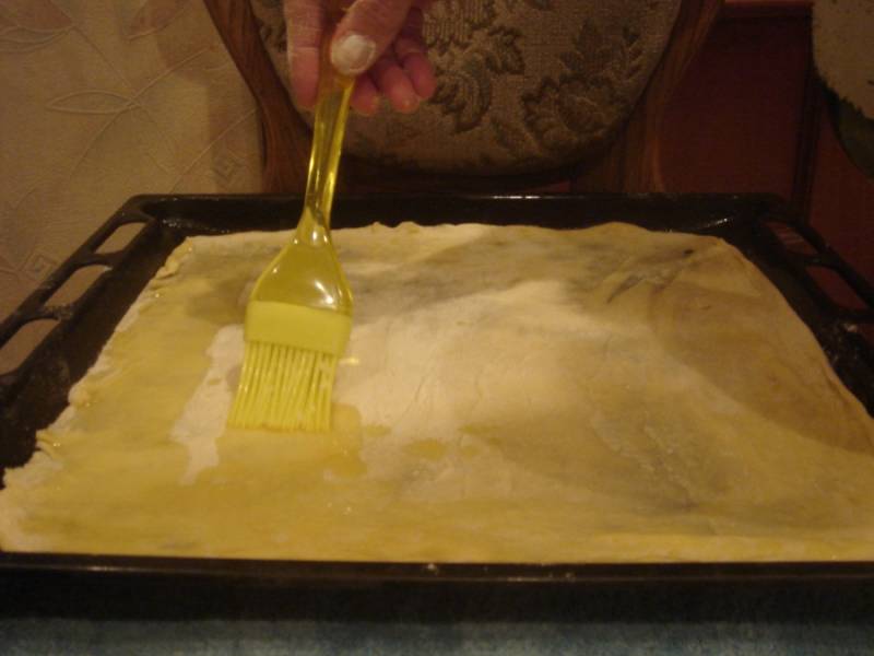 Смазываем растопленным ранее сливочным маслом и посыпаем тертым сыром.