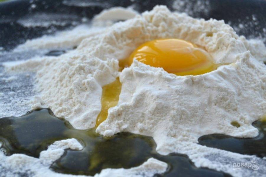 1.	Смешайте муку с солью, в центре сделайте колодец и вбейте в него куриное яйцо.