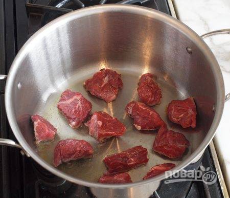 2. На дно кастрюли или сотейника налейте растительное масло, поставьте на огонь. Выложите мясо, обжарьте его на среднем огне несколько минут. 