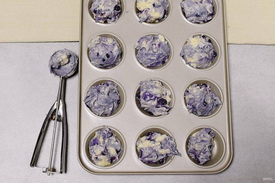 Разложите тесто по формочкам. Удобно это делать ложкой для мороженого.