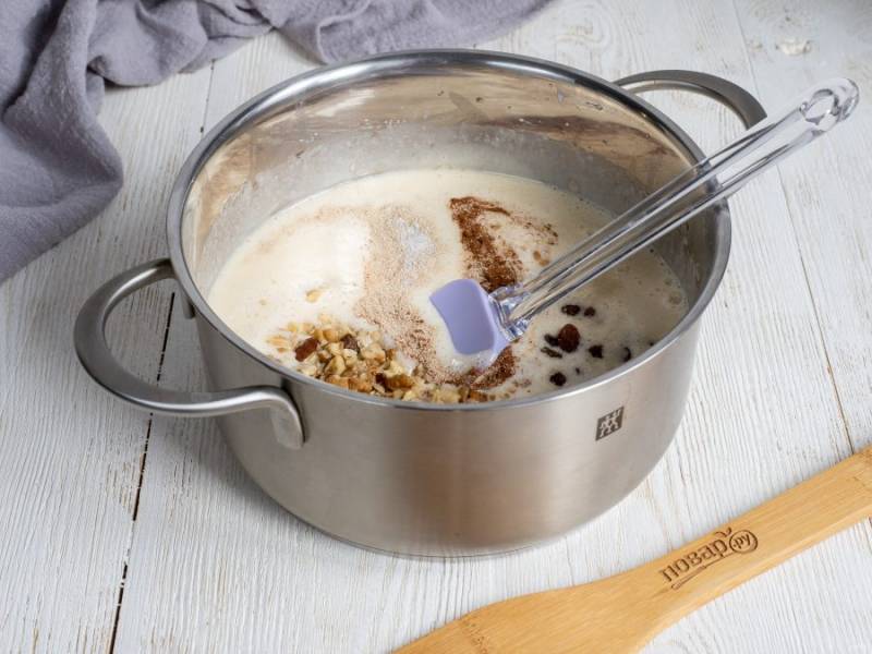 Очищенные орехи положите в пакет и немного помните скалкой. В тесто добавьте дрожжи, корицу, орехи, изюм и соль. Перемешайте лопаткой.
