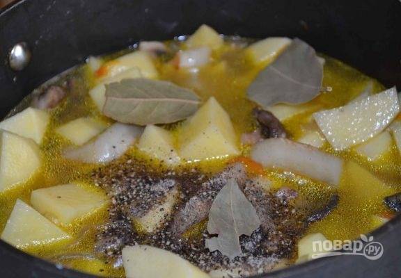 9. Добавьте картофель к остальным овощам. Всыпьте по вкусу соль и специи. Для аромата добавьте лавровый лист. Влейте воду в сотейник, доведите её до кипения. 