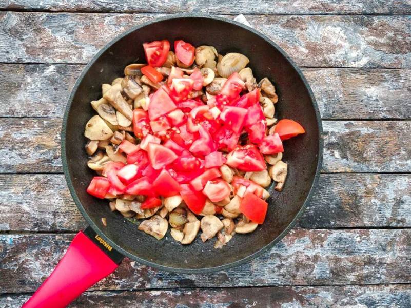 К грибам с луком добавьте нарезанный помидор и хорошо все перемешайте. 