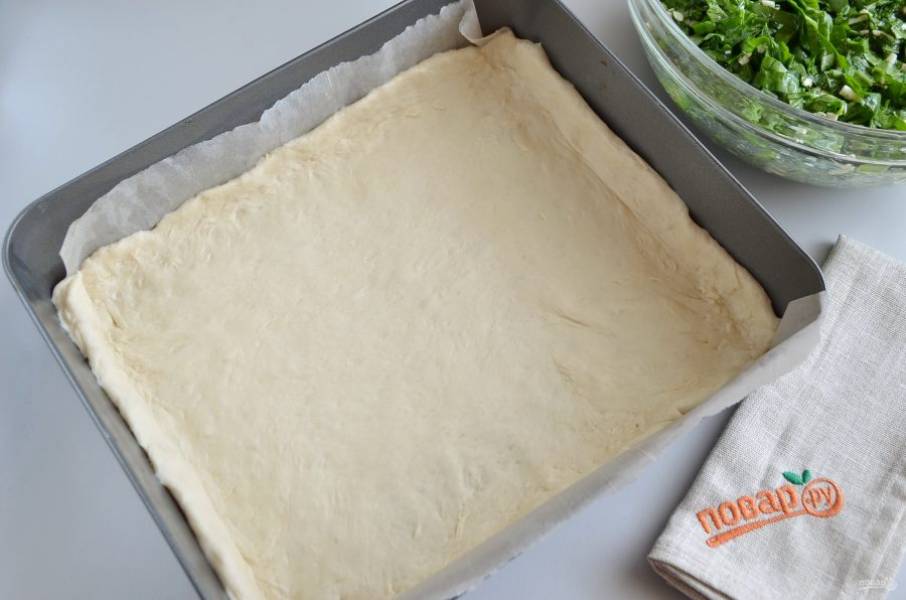 Форму застелите пергаментом, смажьте его маслом растительным. Включите духовку на 200 градусов, пусть прогревается. Тесто раскатайте толщиной 0,5-0,7 мм, расположите его так, чтобы были небольшие бортики.
