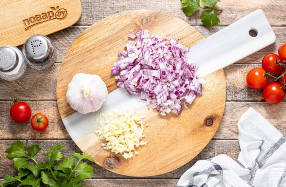 Красный лук нарежьте на мелкие кубики. Чеснок очистите, порубите ножом.