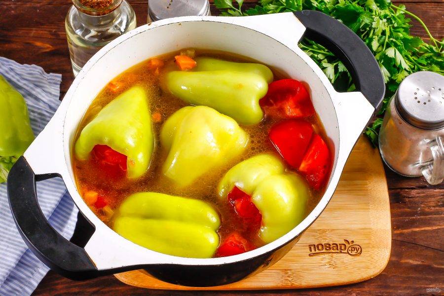 Оставшийся помидор нарежьте кружочками и закройте ими начинку в перцах. Выложите перцы в бульон и тушите блюдо примерно 40-50 минут на умеренном нагреве.