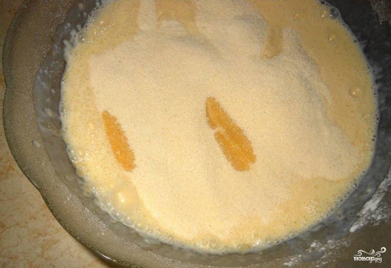 Заливаем тесто кефирной массой. Всыпаем соль. Перемешиваем, чтобы не было комочков. Раскаленное масло вливаем в тесто, насыпаем манку.