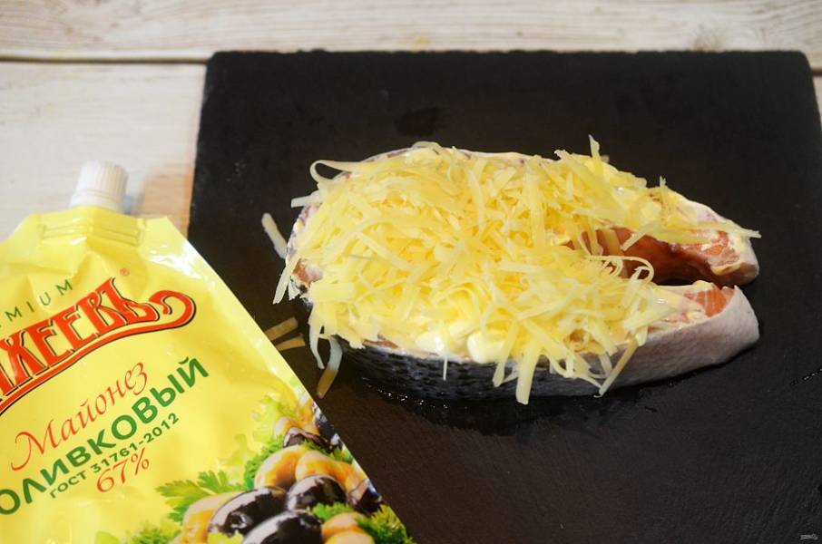 Посыпьте тертым сыром. Закройте рыбу фольгой.