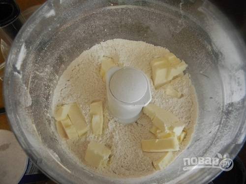 Смешайте муку, сахар, соль и разрыхлитель. Затем добавьте холодное сливочное масло и перебейте в комбайне или перетрите руками в крошку.