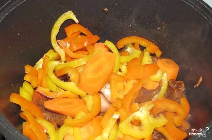 Морковку очистите и крупно нарубите. Из сладкого перца вычистите семена и уберите ножку. Также нарежьте овощ довольно крупно. Положите все ингредиенты в казанок. 