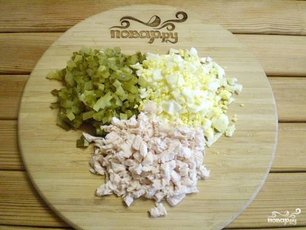 Порежьте кубиками огурцы, яйца и мясо. Оставьте часть огурцов и яиц для украшения.