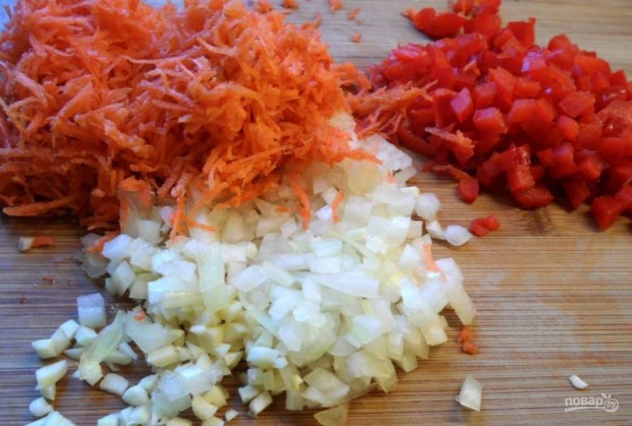Нарежьте мелкими кубиками перец и лук. Морковь натрите на мелкой тёрке. А в это время отварите рис до готовности в подсоленной воде.