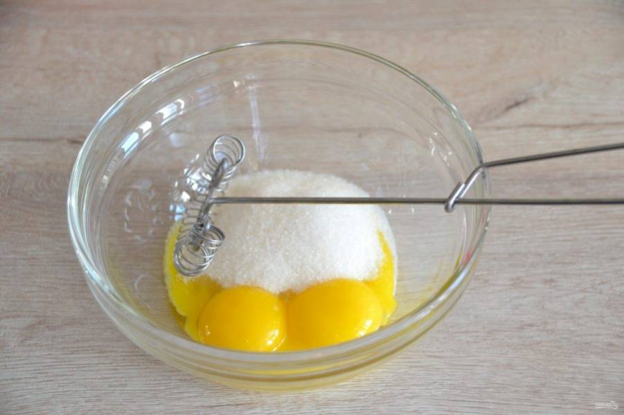 Взбейте венчиком яичные желтки и 1/3 сахарного песка.