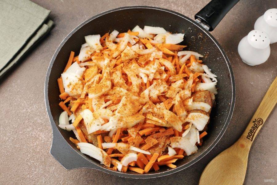 Добавьте нарезанный перьями лук и нарезанную соломкой морковь. Посолите и добавьте специи по вкусу.