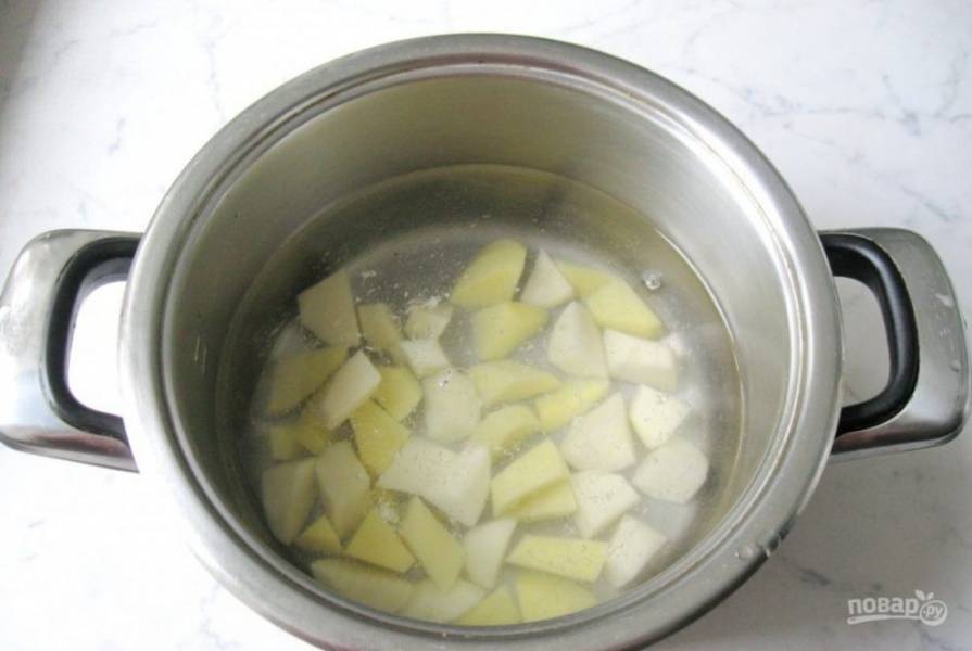 Очищенный и нарезанный кубиками картофель залейте водой в кастрюле. Поставьте вариться.