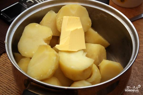 Для начала чистим картошку, хорошенько промываем и выкладываем в кастрюлю. Заливаем водой, солим и ставим на огонь. Когда картошка будет готова, сливаем воду и добавляем кусочек сливочного масла. 