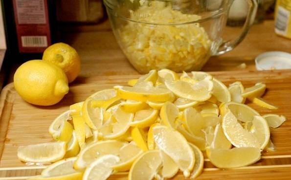 Для начала нам необходимо промыть лимоны под холодной водой и нарезать небольшими дольками. Теперь пропускаем кусочки лимона через мясорубку, впрочем, если мясорубки у вас нет, лимоны можно просто очень мелко нарезать.