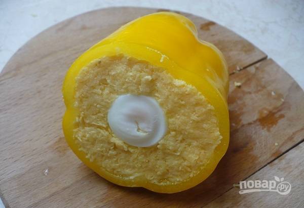 5. Наполните дно и бока начинкой из сыра, в центр вложите яйцо (целиком) и добавьте начинку так, чтобы она плотно заполнила перец. 