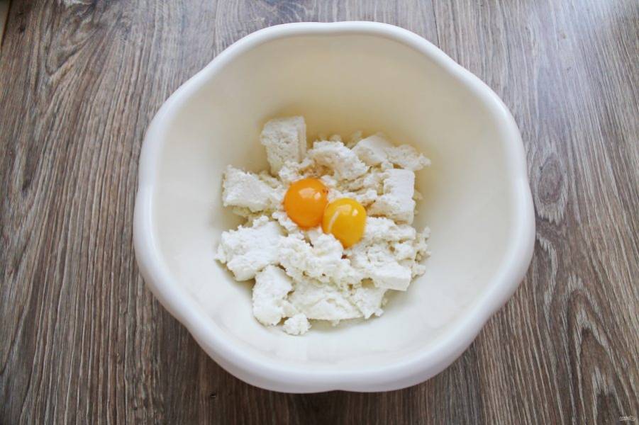 Яйца разделите на белки и желтки. В миску выложите творог и добавьте желтки, белки нам понадобятся позже.