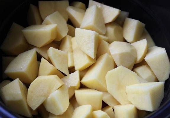 Картофель чистим и режем крупными дольками, выкладываем его вместе с нарезанным мясом в чашу мультиварки. 