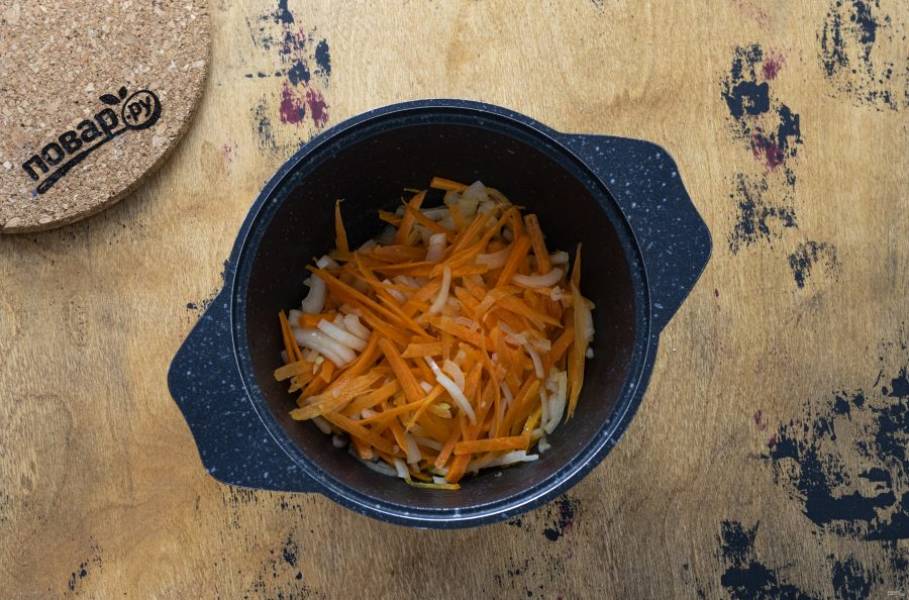 Морковь натрите на терке, лук нарежьте на тонкие полукольца. Разогрейте в кастрюле с толстым дном растительное масло и обжарьте овощи до золотистого цвета.