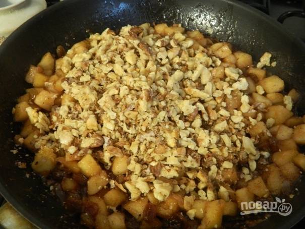 Поджаренные орехи необходимо измельчить с помощью ножа или скалки и добавить их на сковороду к яблокам.