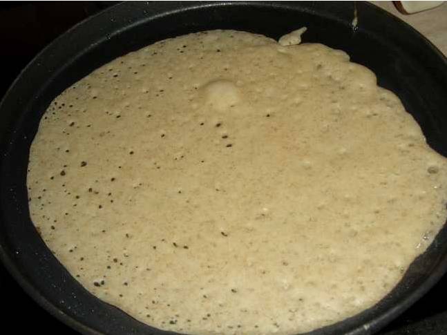 2. Когда тесто увеличится в объеме в полтора-два раза, обминаем его и начинаем печь блины на сухой раскаленной сковороде.