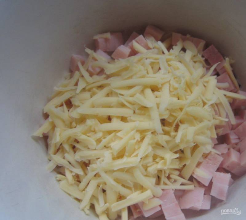 1. Этот салат готовится с ветчиной, поэтому к ее выбору нужно подойти с особой тщательностью. Нарезаем ветчину соломкой и отправляем в емкость, в которой будем замешивать салат. Добавляем натертый на средней терке сыр.