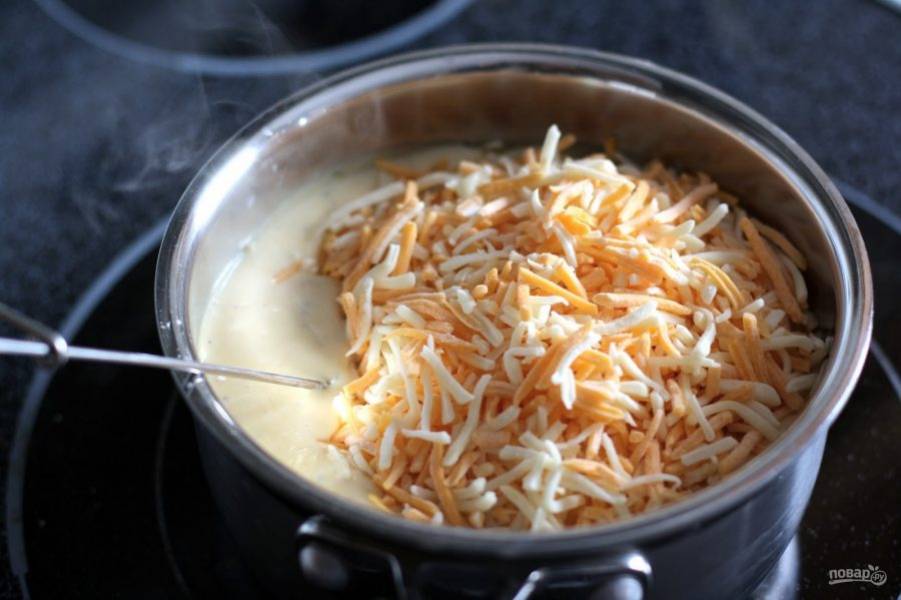 Натрите оба вида сыра (можно использовать и один). Когда соус начнет кипеть, всыпьте сыр, убавьте огонь до минимума и вымешивайте соус, пока сыр полностью не расплавится.