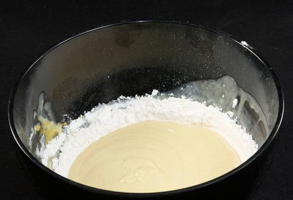2. В отдельную мисочку просеять муку с содой (или разрыхлителем). Соединить часть муки с яйцом и начать взбивать тесто. 