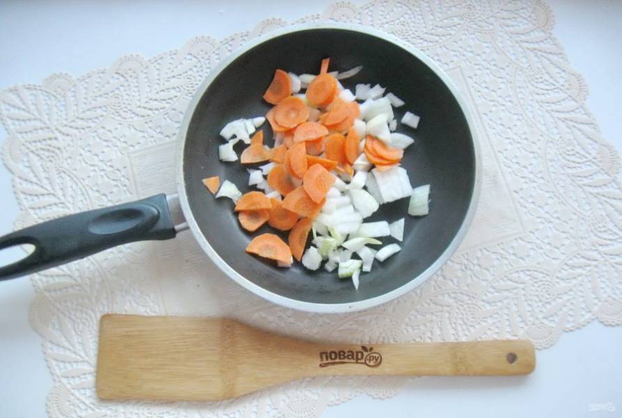 Репчатый лук и морковь очистите, помойте и нарежьте. Выложите в сковороду. Налейте подсолнечное масло и тушите овощи 7-8 минут, периодически перемешивая.