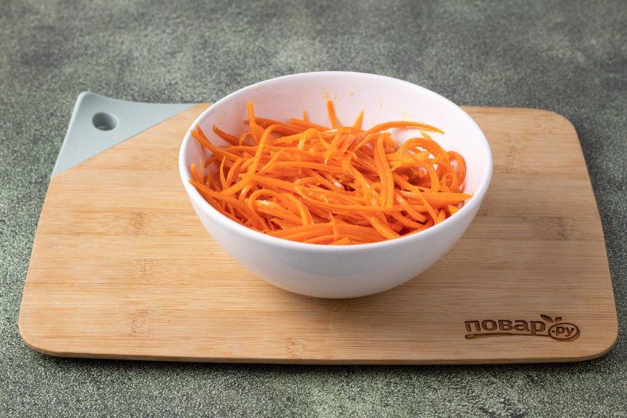 Морковь тоже очистите и натрите на терке для моркови по-корейски. Добавьте соль, сахар, острый молотый перец, приправу для моркови по-корейски и тертый чеснок. Разогрейте вторую часть растительного масло и полейте им морковь, пока масло еще дымит. Заправьте яблочным уксусом, все перемешайте и уберите на 2 часа в холодильник.