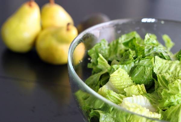 4. Выложите зелень в салатник, очистите и нарежьте небольшими кубиками груши. 