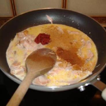 В сковороде растопите немного сливочного масла, добавьте сливки, чайную ложку черного перца, немного томатной пасты и кусочки лосося. 