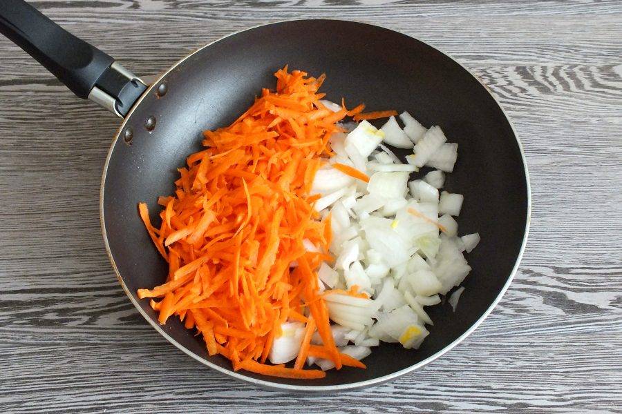 На крупной терке натрите морковь, лук нарежьте произвольно. В сковороде разогрейте растительное масло. Переложите овощи и обжарьте до готовности.
