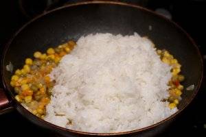 Добавьте отваренный рис, а также соль и специи .