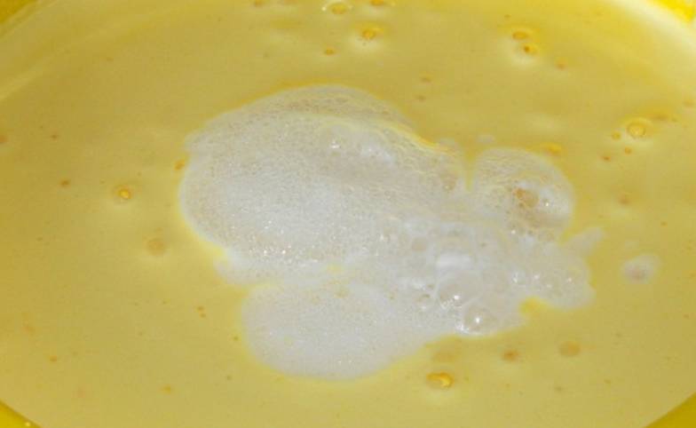 Когда все желтки взбиты, добавьте гашенную уксусом соду.