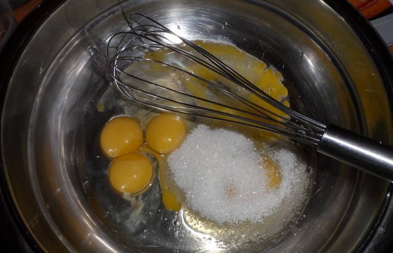 В глубокую миску разбиваем яйца и добавляем сахар. Взбиваем их до тех пор, пока объем массы не увеличится в два раза. 