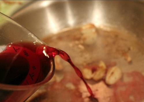 4. На сковороду влить немного красного (лучше сухого) вина. Затем добавить немного бульона (если мясо будет доводиться до готовности на сковороде, а не в духовке). 